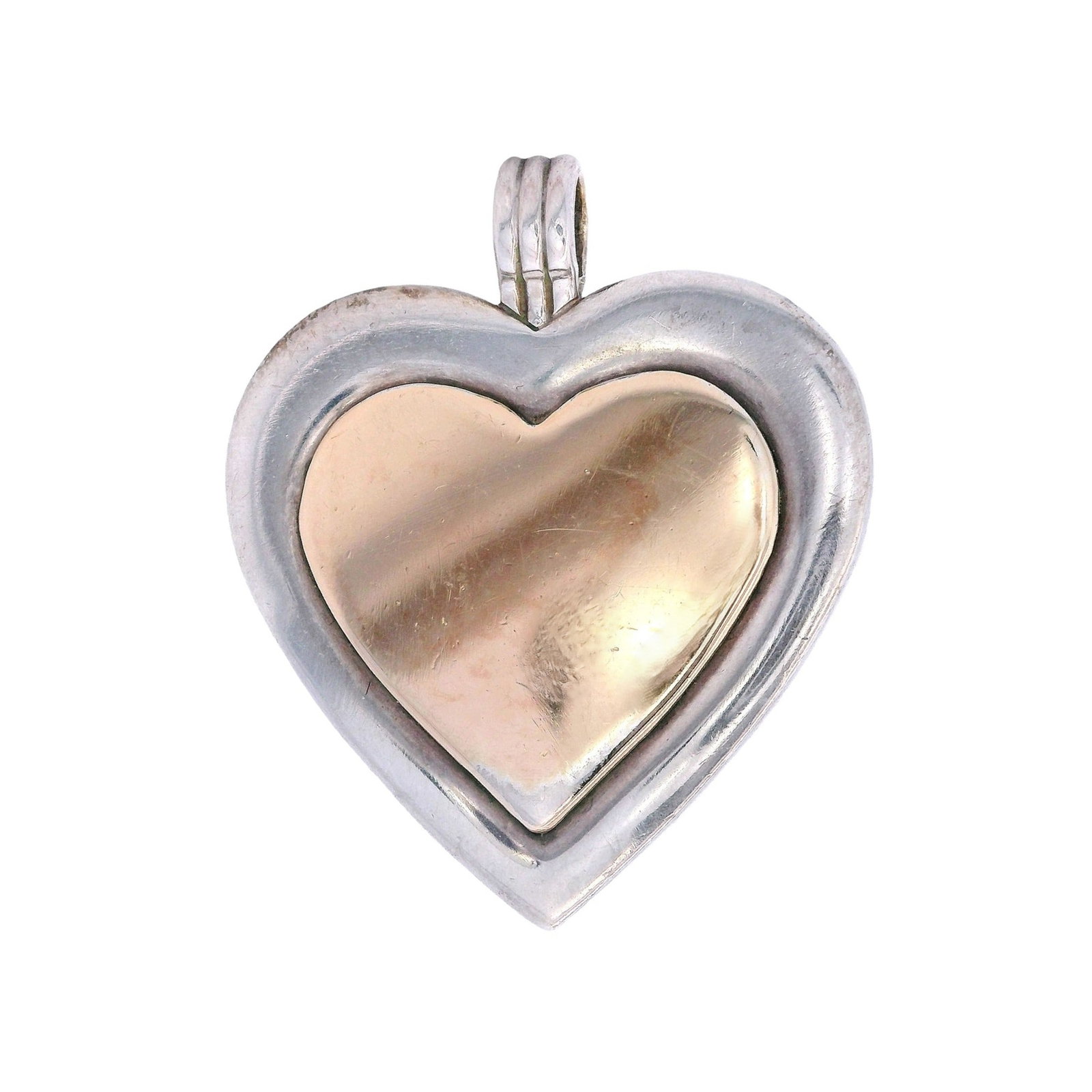 Tiffany & Co. Vintage 18kt yellow Gold & Sterling Silver Heart Pendant: Vintage Heart by Tiffany & Co. Crafted with Sterling Silver 925 and 18kt yellow Gold on the center. Measurements: 1.20 x 1.0 inches. Total weight: 12.25 grams. Stamped: "Tiffany & Co. 18Kt TRIM, Sterl