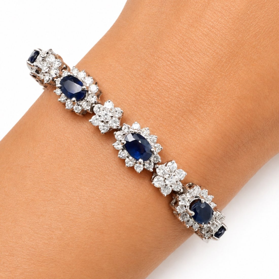 18K White Gold Bracelet with 9.50 CTW in Sapphire & Diamond: Brilliant 18K white gold sapphire and diamond bracelet set with nine sapphires totaling approximately 5.00 CTW, offering rich blue color and elegant contrast throughout the design. Accented with 184 d