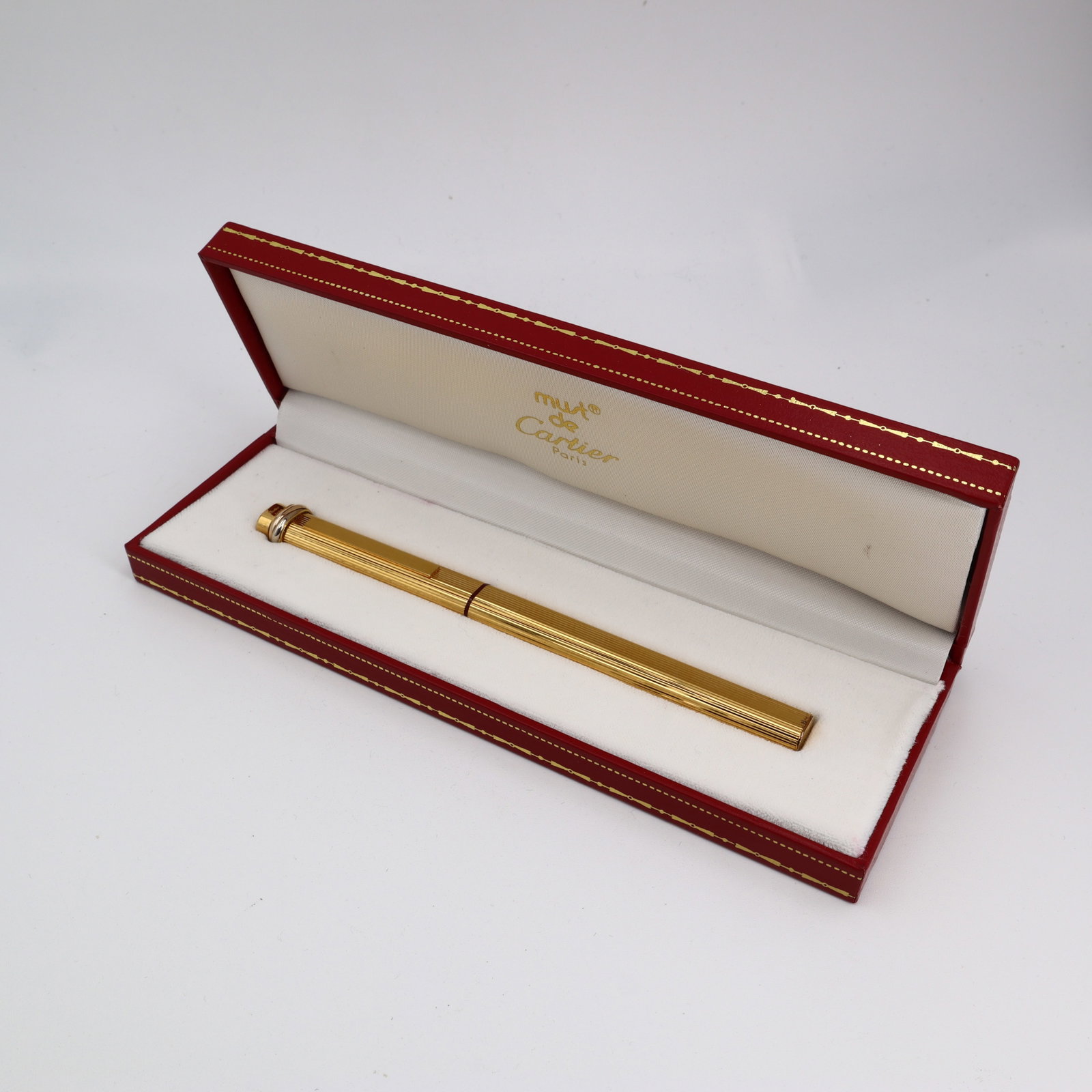 Cartier Vendôme Trinity 18K Gold-Plated Ballpoint Pen with Box (Model 275311): Elegant Cartier Vendôme “Trinity” ballpoint pen, finished in 18K gold plate with a finely textured barrel and a distinctive twisted Trinity detail at the crown. This model 275311 feat