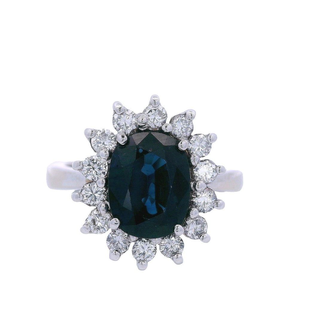 Vintage 18kt white Gold Halo Ring with Sapphire and Diamonds: This elegant 1980s-1990s modernist ring in size 5 1/4 (resizable) is expertly crafted in 18k white gold and measures 0.55 inches in width. Features a vibrant oval-shaped blue sapphire (approximately 1