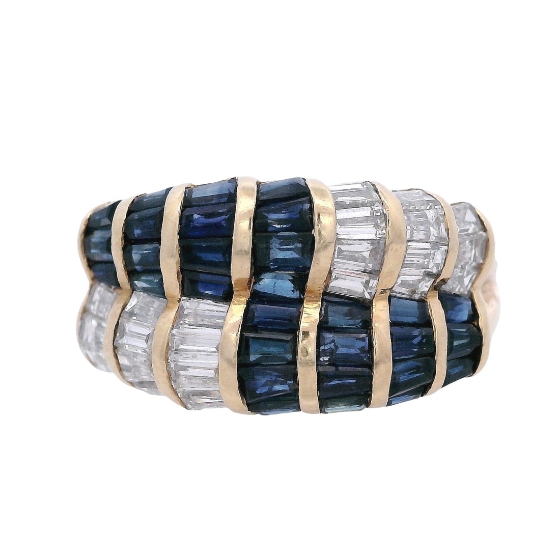 18K Yellow Gold Ring with 2.65 CTW in Blue Sapphire & Diamonds: Striking 18K yellow gold band ring designed in bold, sculptural rows, set with 30 calibrated tapered baguette blue sapphires totaling approximately 1.50 ctw and 22 tapered baguette diamonds totaling a