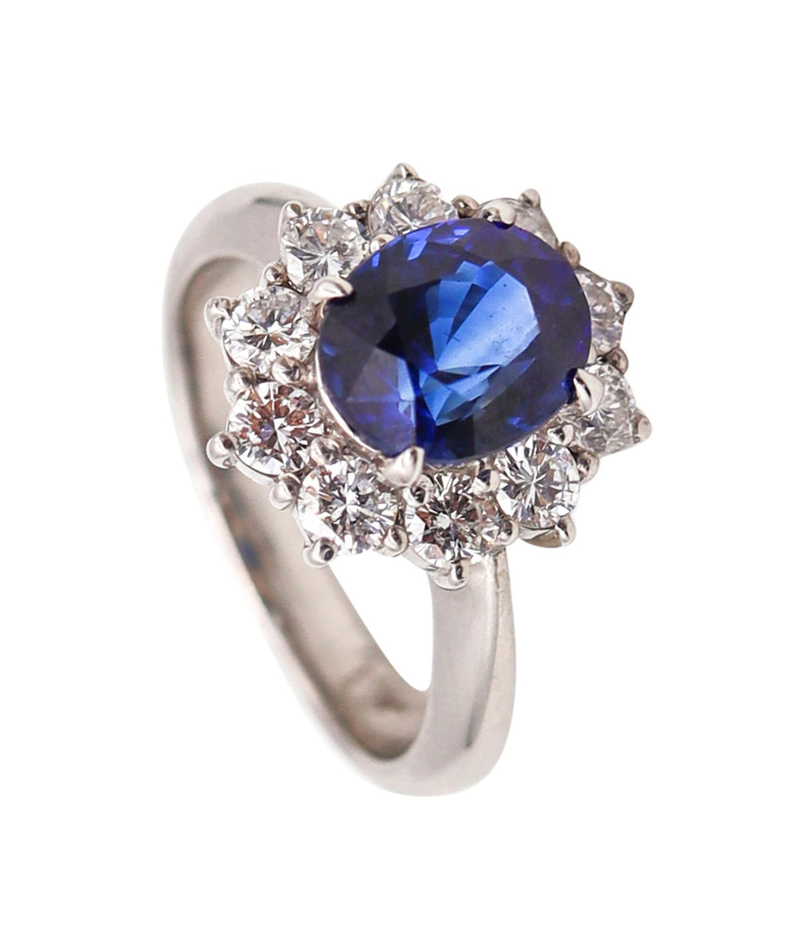 CLASSIC Halo Ring In Platinum With 3.14 Ctw In Sapphires And Diamonds: Beautiful contemporary halo ring, crafted in solid .900 platinum with a high-polish finish and a classic, elegant silhouette. Centered with an oval faceted vivid royal-blue sapphire in four prongs (8 