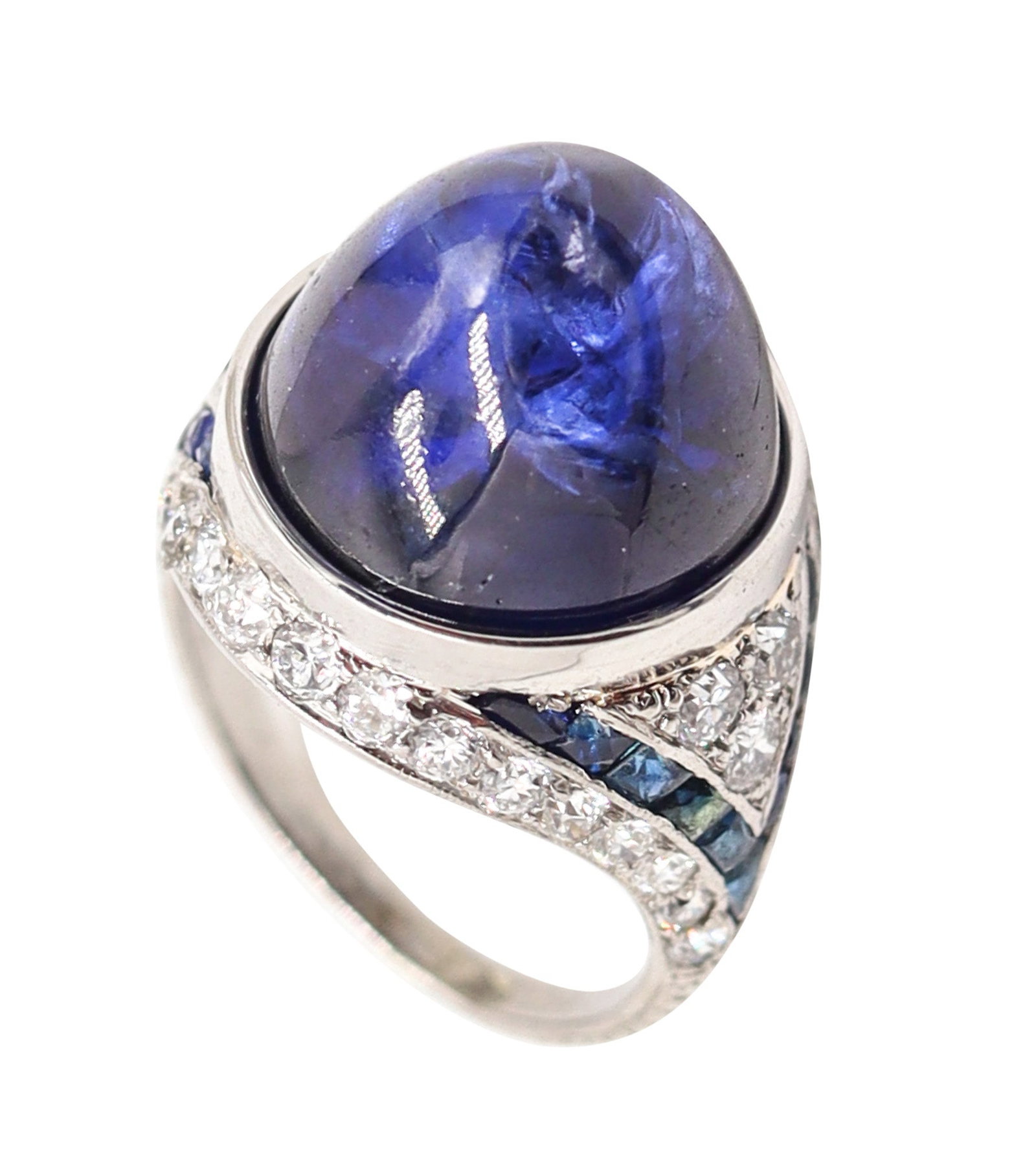 ART DECO 1920 Platinum Cocktail Ring With 26.65 Cwt. In Sapphires And Diamonds: Gorgeous Art Deco bombe ring, America, circa 1925–1930, masterfully hand crafted in platinum/iridium (.900 Pt, .100 Ir) with a polished finish and all original stones. Centered with an outstandi