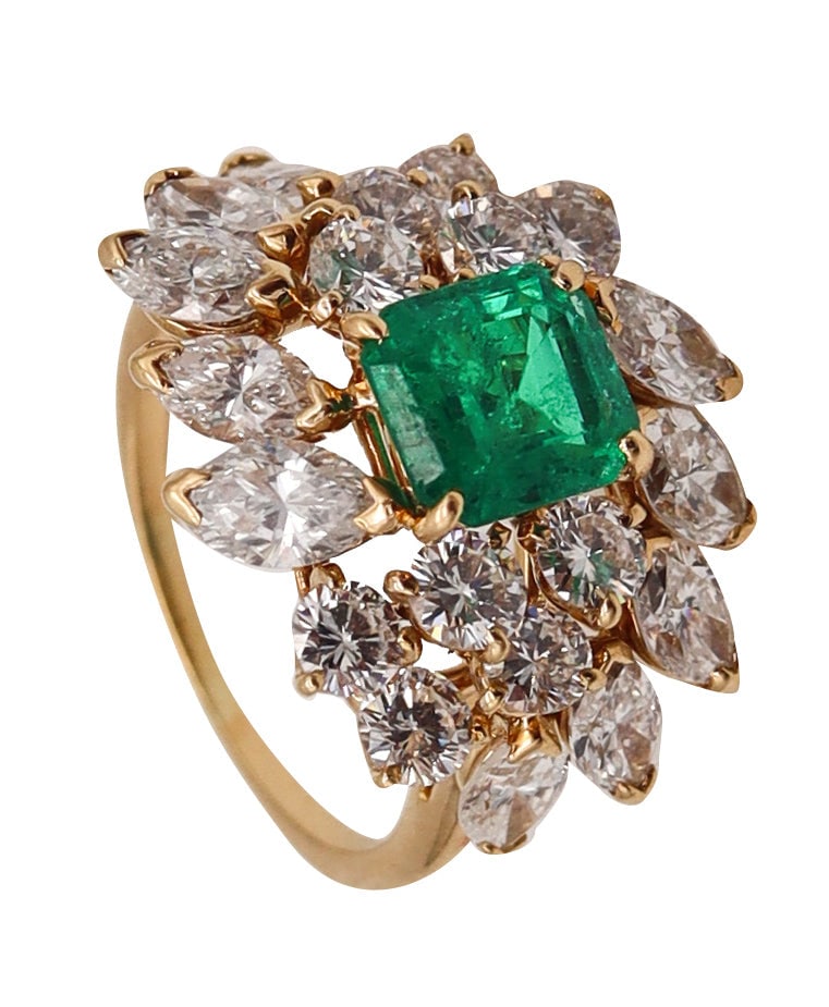 Cluster Cocktail Ring In 18Kt Yellow Gold With 5.58 Ctw In Colombian Emerald And Diamonds: Statement cocktail ring crafted in solid 18K yellow gold and centered with a vivid Colombian emerald in four prongs (rectangular faceted, 7.02 x 6.52 x 4.32mm; 1.44 ct). Brilliantly framed by 20 diamo