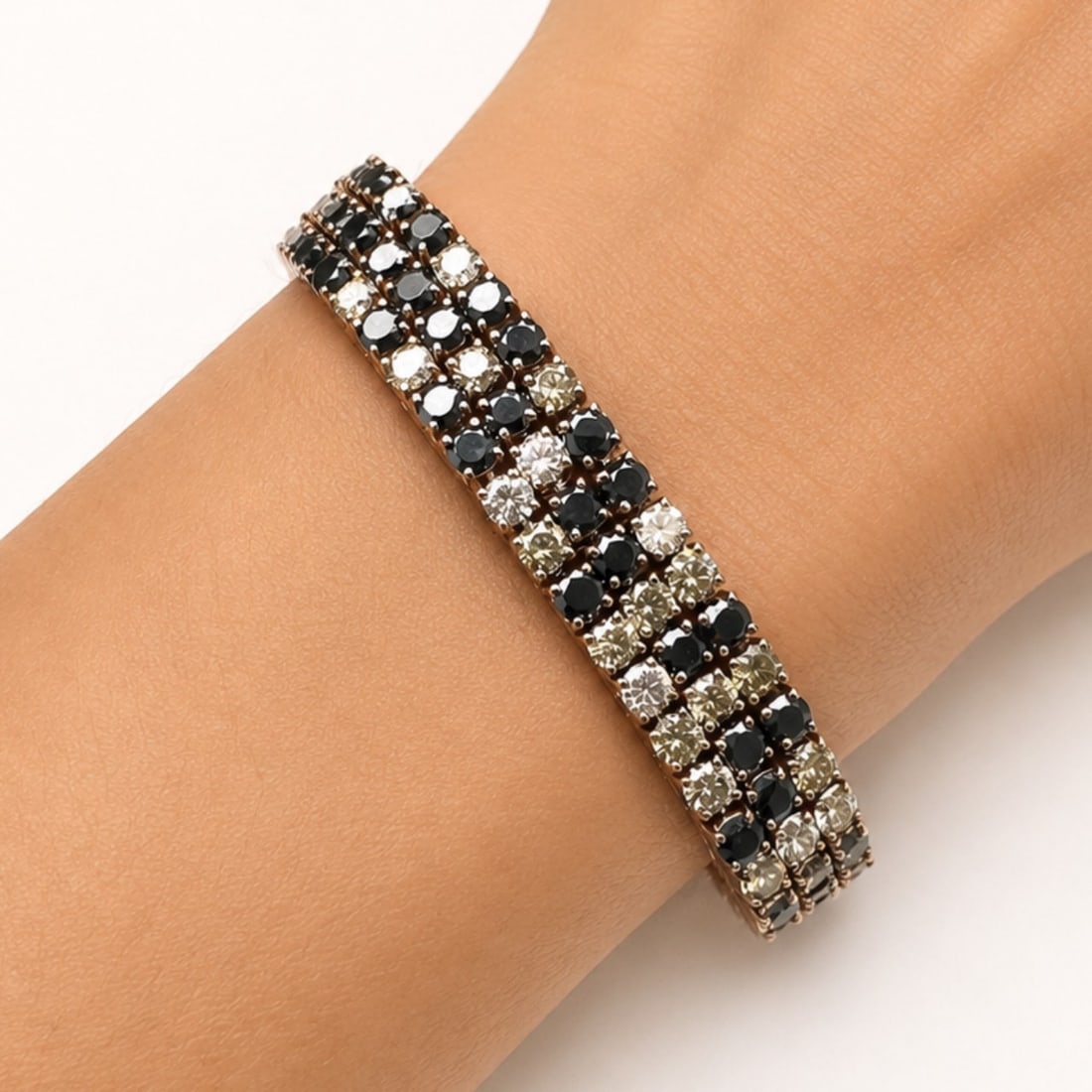 18K Rose Gold Bracelet with 7.47 CTW in White, Champagne & Black Diamond: Striking bracelet crafted in 18K rose gold, designed in a bold multi-row layout with alternating white, champagne, and black diamonds for rich contrast and a modern, graphic look on the wrist. Set wit