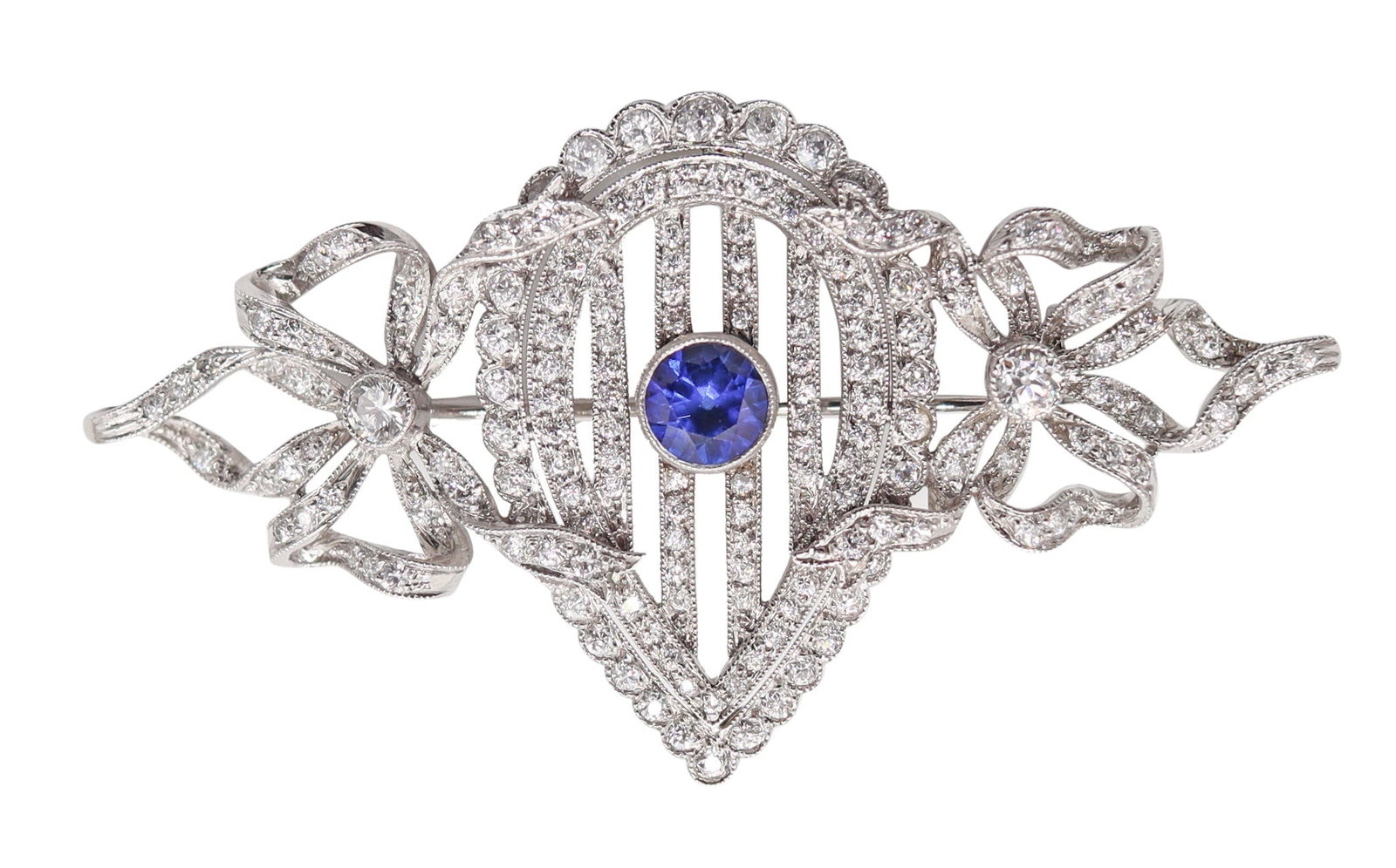 J.E. CALDWELL 1910 Edwardian Brooch In Platinum With Diamonds & Sapphire: American Edwardian/Belle Époque jewel by J.E. Caldwell & Co., Philadelphia, circa 1900–1910, crafted in solid platinum with refined period workmanship. Centered with a bezel-set round facet