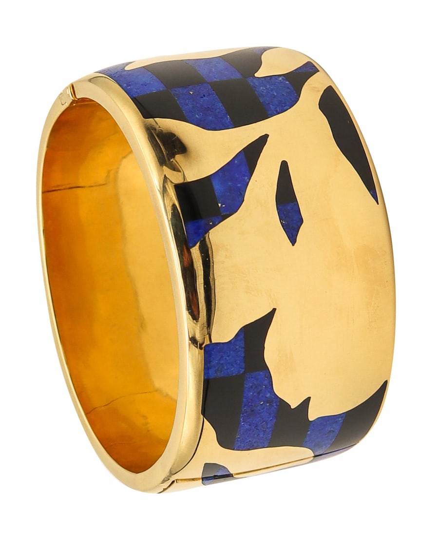 TIFFANY & CO. 1977 Angela Cummings Geometric Orchids Bangle In 18Kt Jade & Lapis: Rare Angela Cummings bangle for Tiffany Studios, New York, circa 1978, crafted in solid 18K yellow gold with a high-polish finish and vivid inlaid hardstone work. Decorated with carved natural black j