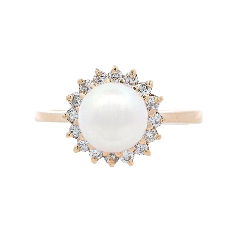 Vintage 14K Yellow Gold Ring with 0.15 CTW in Diamonds & Pearl: Vintage 14K yellow gold ring centered with a luminous pearl, framed by a sparkling halo of round-cut diamonds totaling approx. 0.15 ctw (H color) for a classic, feminine look. Total weight 3.50 grams;
