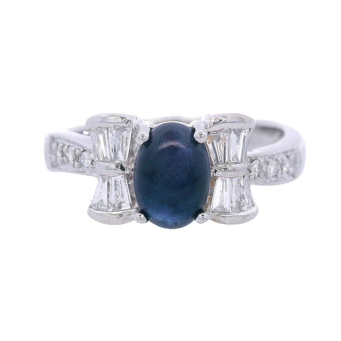 18kt white Gold Ring with Sapphire & Diamonds: 18kt white Gold Ring featuring a center Cabochon blue Sapphire of Approx. 1.35 carats. Along with tapered Baguette and Round cut Diamonds weighing together Approx. 0.55 carats. F-G color, VS1 clarity.