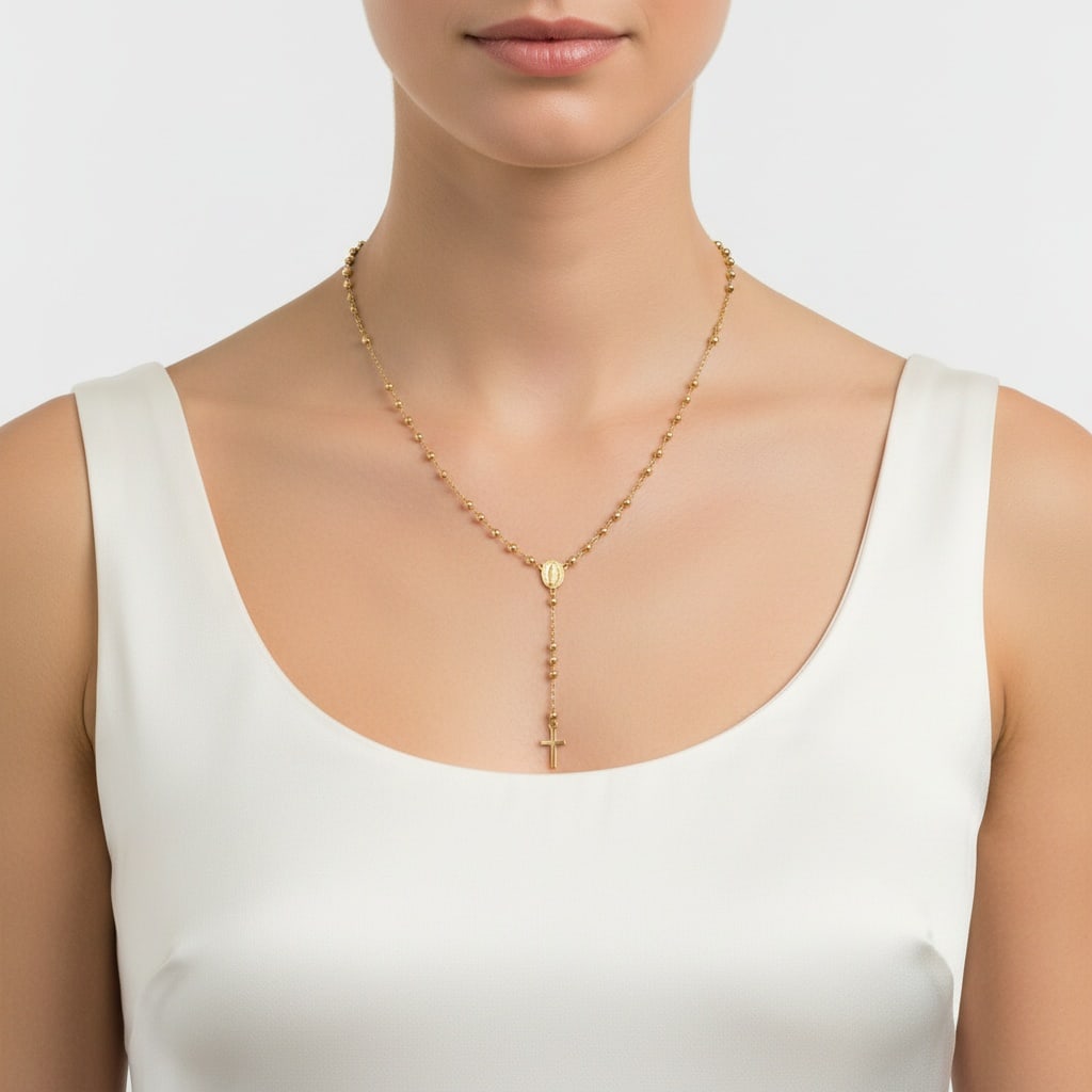Vintage 18K Yellow Gold Rosary Necklace: 18K yellow gold rosary necklace featuring a fine bead chain with a center medallion and drop chain finished with a cross. Total length 21 inches. Total weight 8.10 grams.