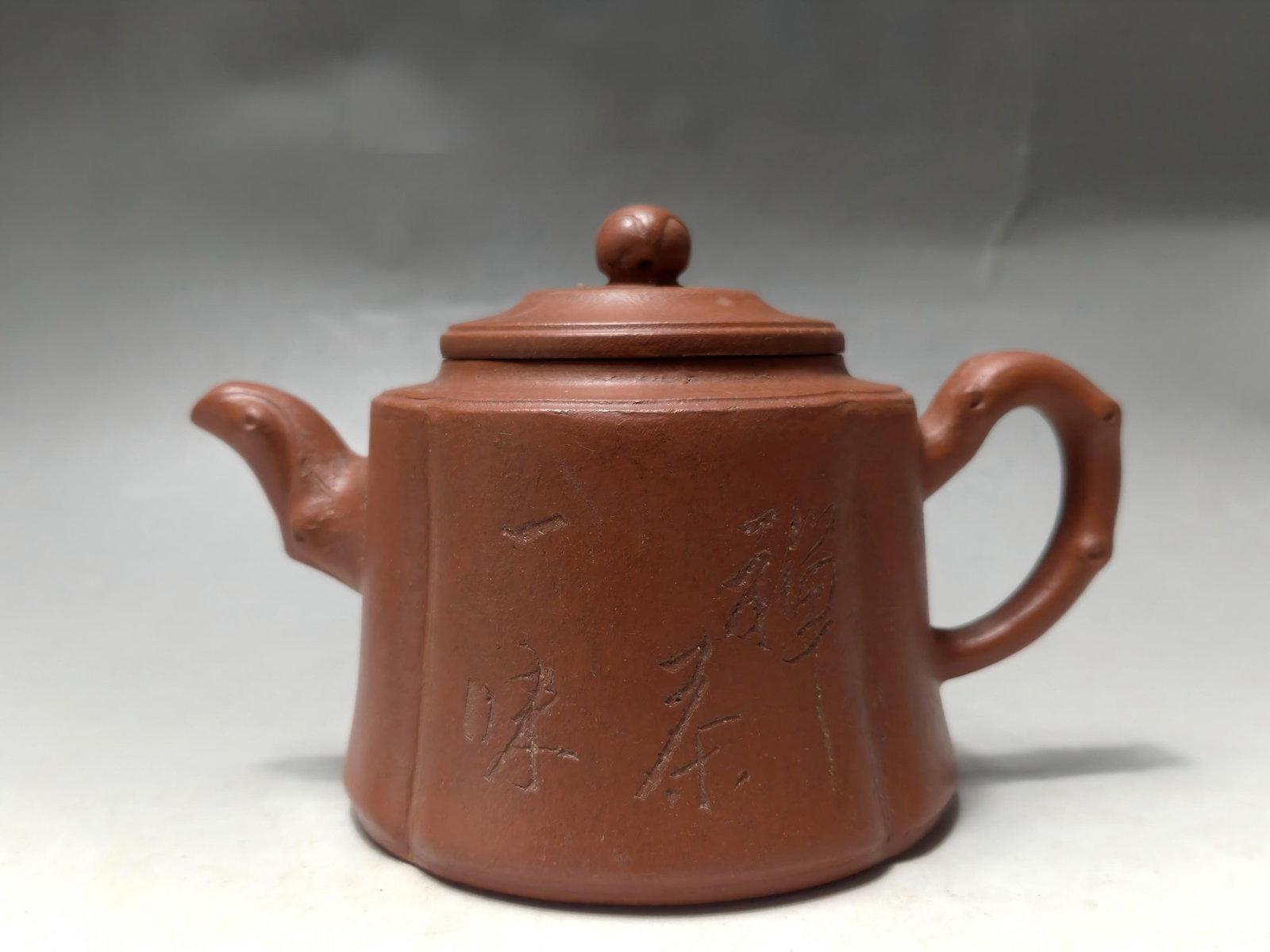 A purple clay teapot made by Gu Jingzhou (formerly in the collection): This is a Zisha teapot made by Gu Jingzhou, formerly in the collection. The clay is warm and lustrous, with an antique patina. The body of the teapot is inscribed with "Zen and Tea are One," conveying
