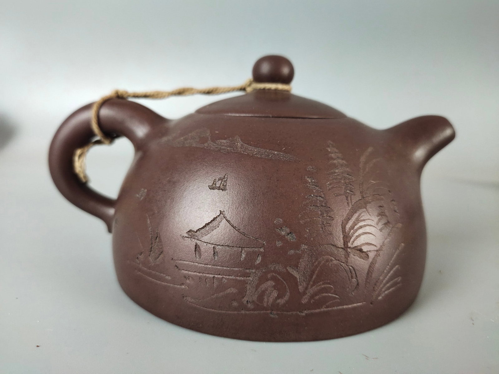 "Chen Guanhou" style purple clay teapot: This Yixing teapot, bearing the inscription "Chen Guanhou," is crafted from fine old purple clay. Its shape is regular and stable, exquisite and elegant. The clay used is pure, with a lustrous color,