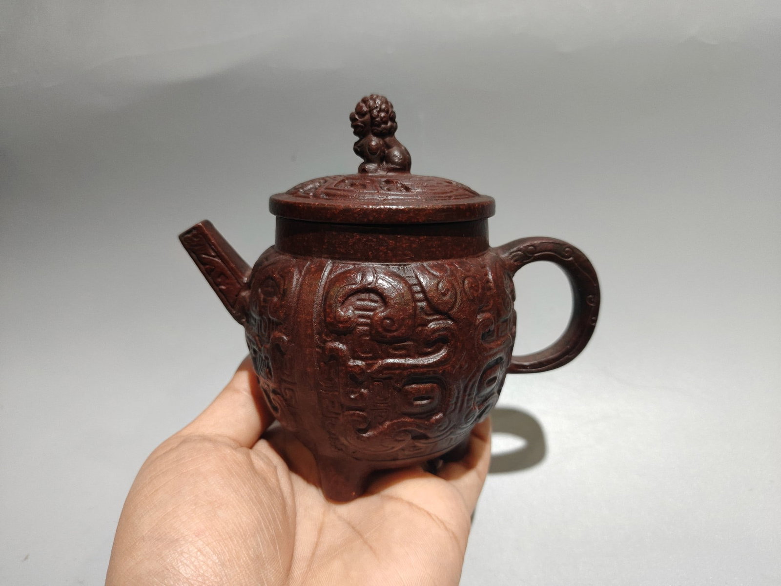 Three-legged imprint teapot: Product Name: Three-Legged Seal Teapot; Bottom Mark: Chen Mingyuan; Size: 14 x 13 cm; Capacity: 280cc; Clay: Original Old Purple Clay Provenance:from the collection of George Stopher, Kent, purchased