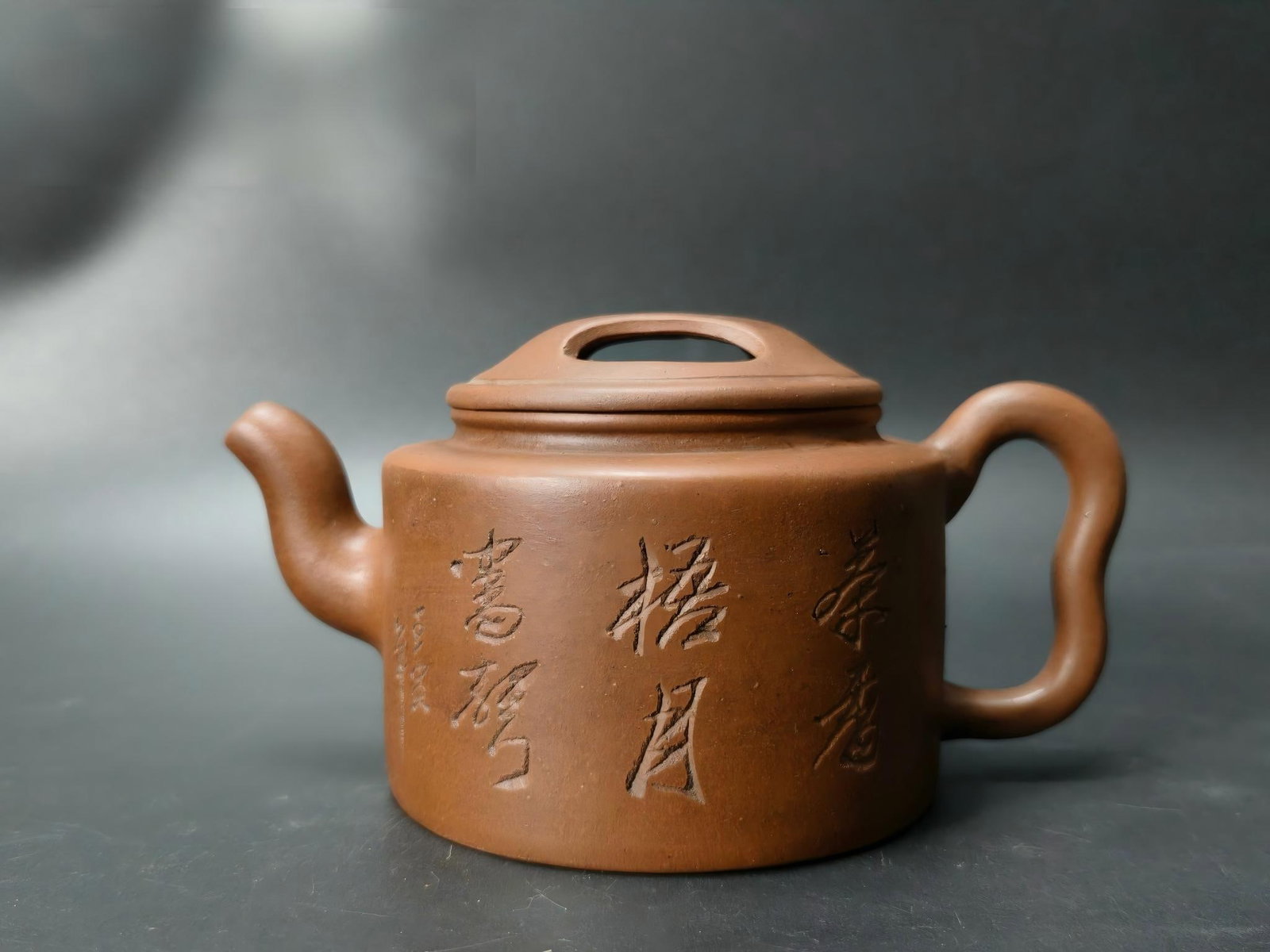 Republic of China Era Old Purple Clay Ox-Lid Teapot: This vintage Republic-era purple clay teapot with an ox-shaped lid boasts a dignified and stable form, its clay a warm and rustic color. The body is inscribed with the calligraphy "Tea Fragrance, Wuto