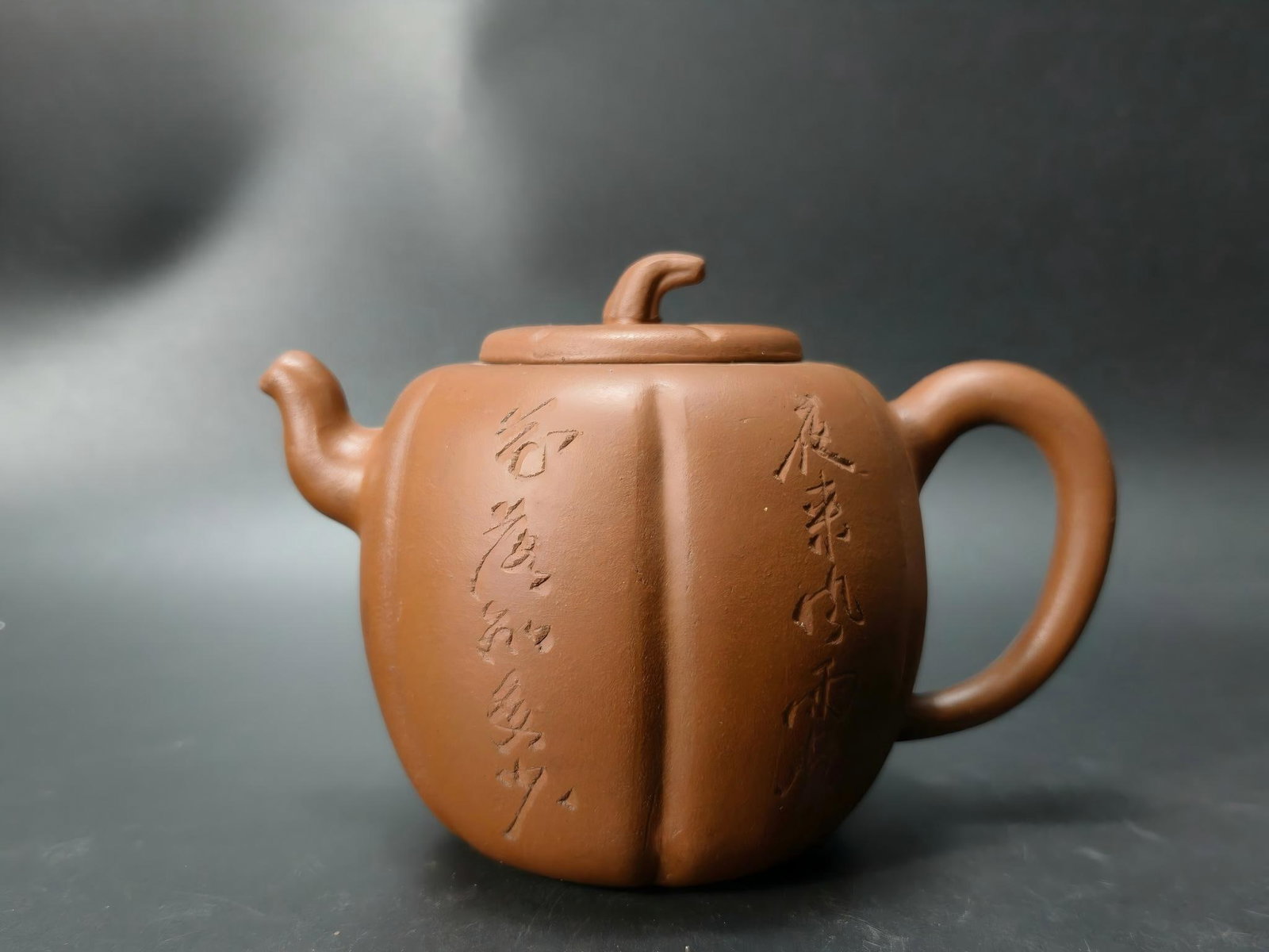 Zhou Jishan made melon-shaped purple clay teapots: This melon-shaped purple clay teapot, crafted by Zhou Jishan, is shaped like a pumpkin, with rounded and full lines. The lid is cleverly designed as a melon stem, adding a touch of natural charm. The