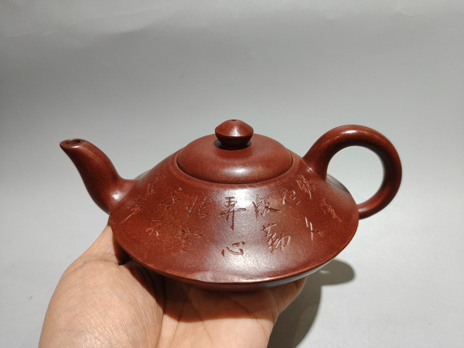 Engraved flat pot: Product Name: Incised Flat Teapot; Bottom Mark: Made by Yu Guoliang of Xishan; Size: 18 x 8 cm; Capacity: 380 cc; Clay: Original Red Clay Provenance:Private collection, Liverpool, The United Kingdom.