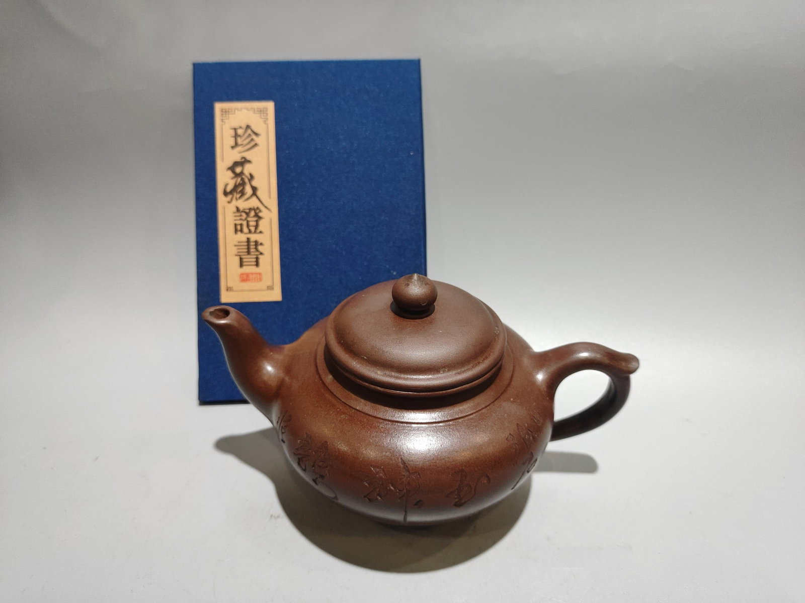 Laughing Cherry Pot: Product Name: Smiling Cherry Blossom Teapot; Bottom Mark: Gu Jingzhou; Size: 16 x 10 cm; Capacity: 280 cc; Clay: Original Old Purple Clay Provenance:Private collection, Liverpool, The United Kingdom. 