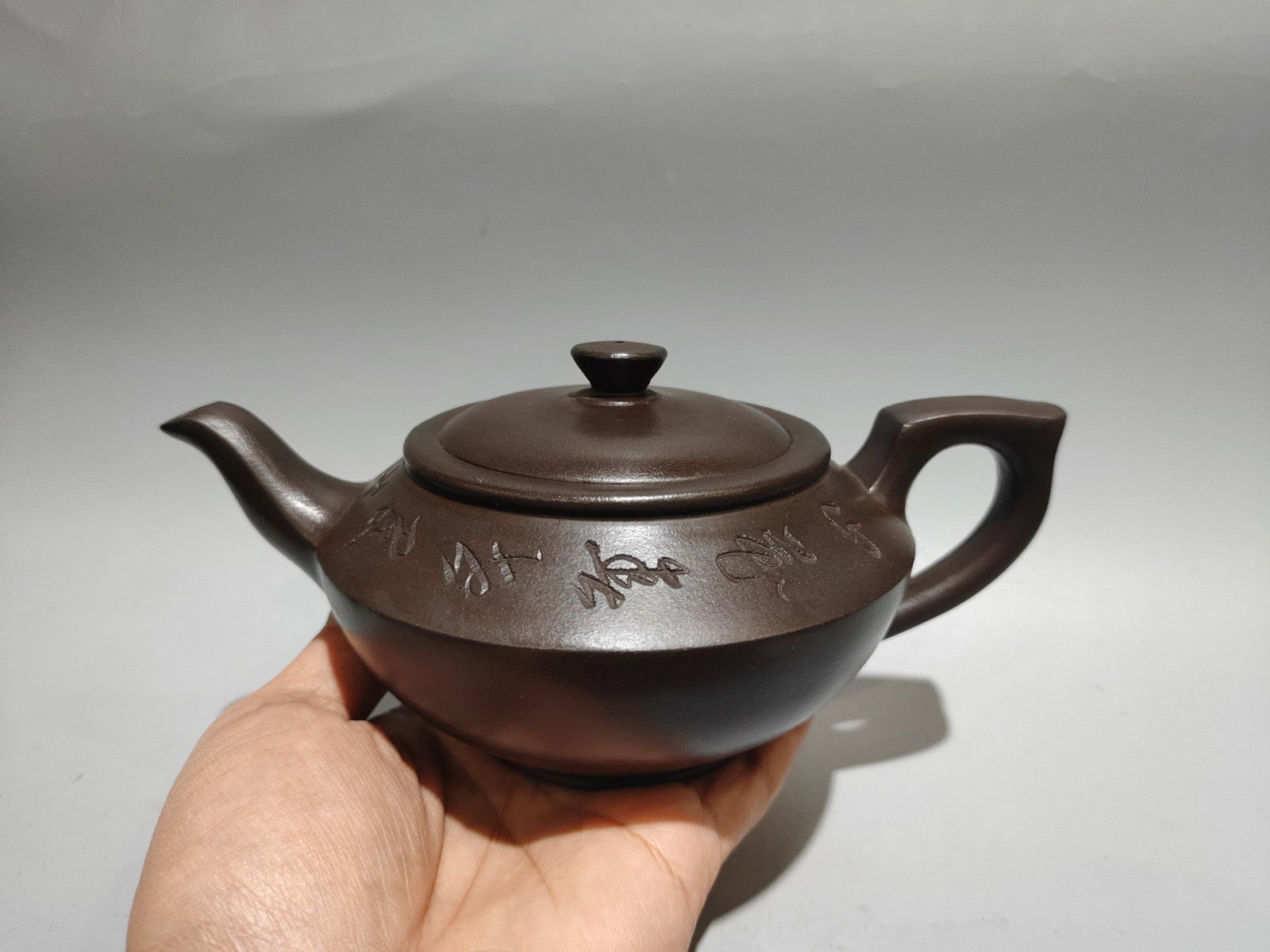 Engraved flat pot: Product Name: Incised Flat Teapot; Bottom Mark: Gu Jingzhou; Size: 19/9cm; Capacity: 360cc; Clay: Original Purple Clay Provenance:Private collection, Liverpool, The United Kingdom. We have an in-house