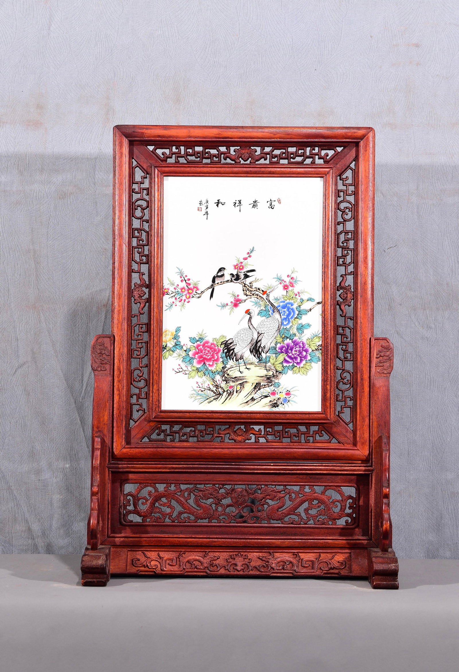 Exquisite! A vertical table screen with a famille rose porcelain panel depicting flowers and birds,: Exquisite! A vertical table screen with a famille rose porcelain painting of flowers and birds in a mahogany openwork frame! "Wealth and Harmony" Dimensions: Height 67cm, Width 47cm Provenance:Private