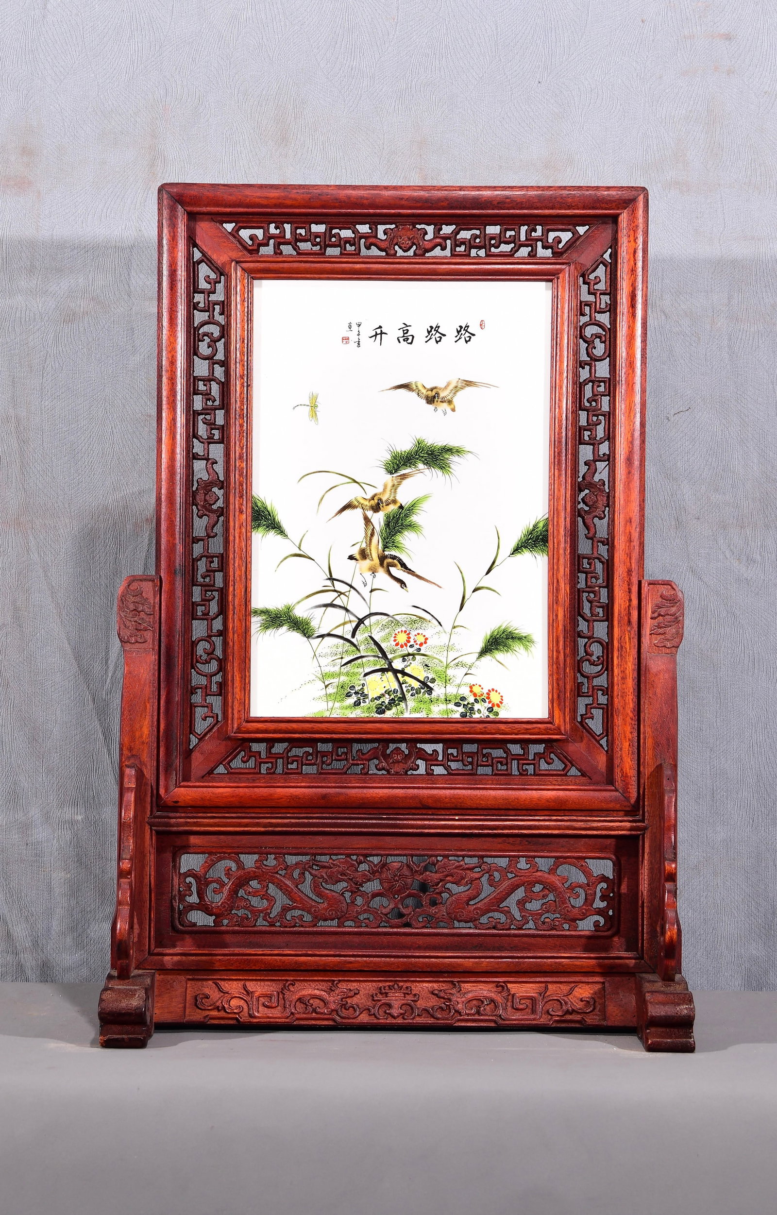 Exquisite! A vertical table screen with a famille rose porcelain painting of flowers and birds set: Exquisite! A vertical table screen with a famille rose porcelain painting of flowers and birds set in a mahogany openwork frame! Title: "Rising Success on All Fronts" Dimensions: Height 67cm, Width 47