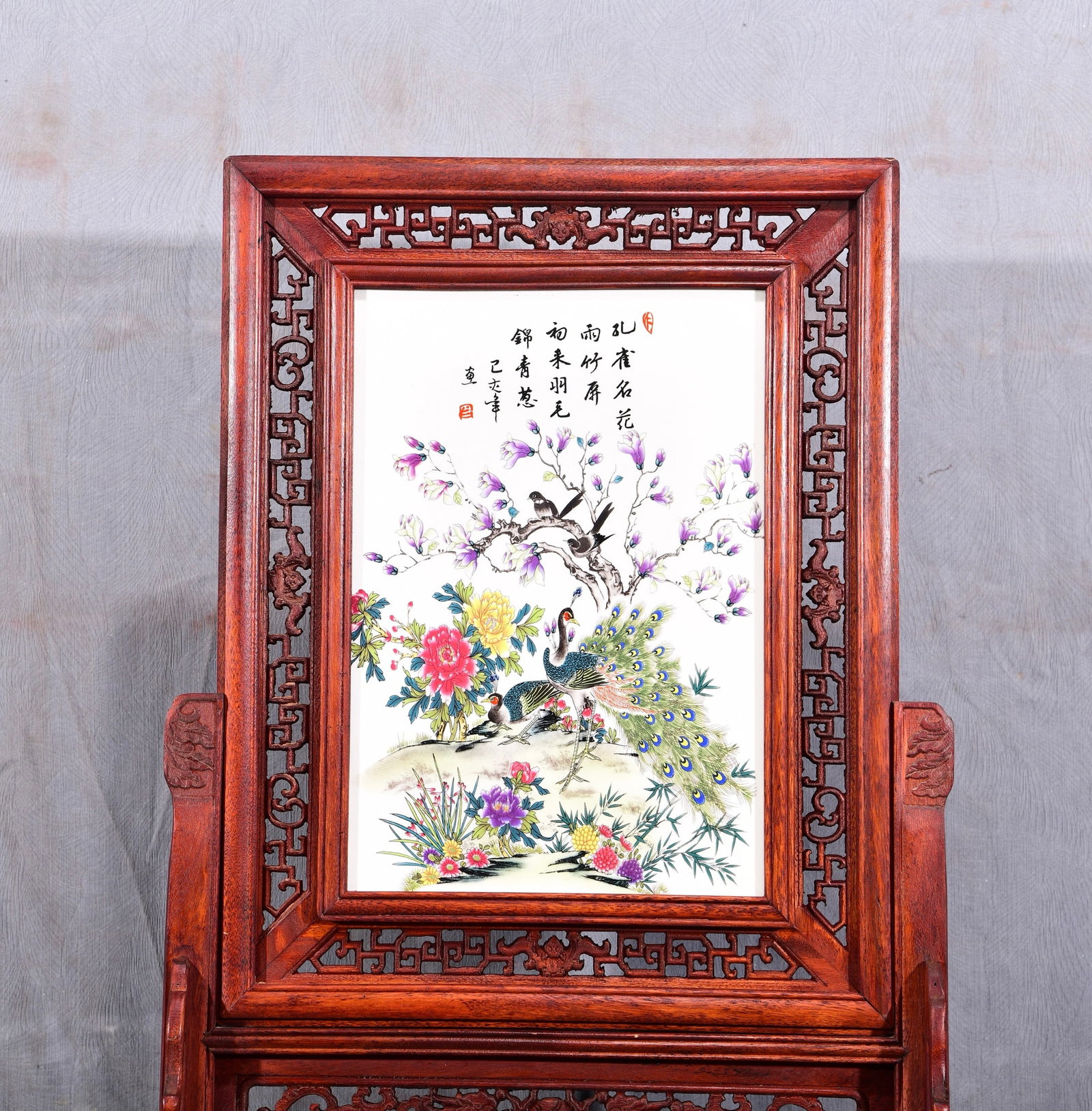 Exquisite! A vertical table screen with a famille rose porcelain panel depicting flowers and birds,: Exquisite! A vertical table screen with a famille rose porcelain painting of flowers and birds set in a mahogany openwork frame! Title: "Wealth and Prosperity" Dimensions: Height 67cm, Width 47cm Prov