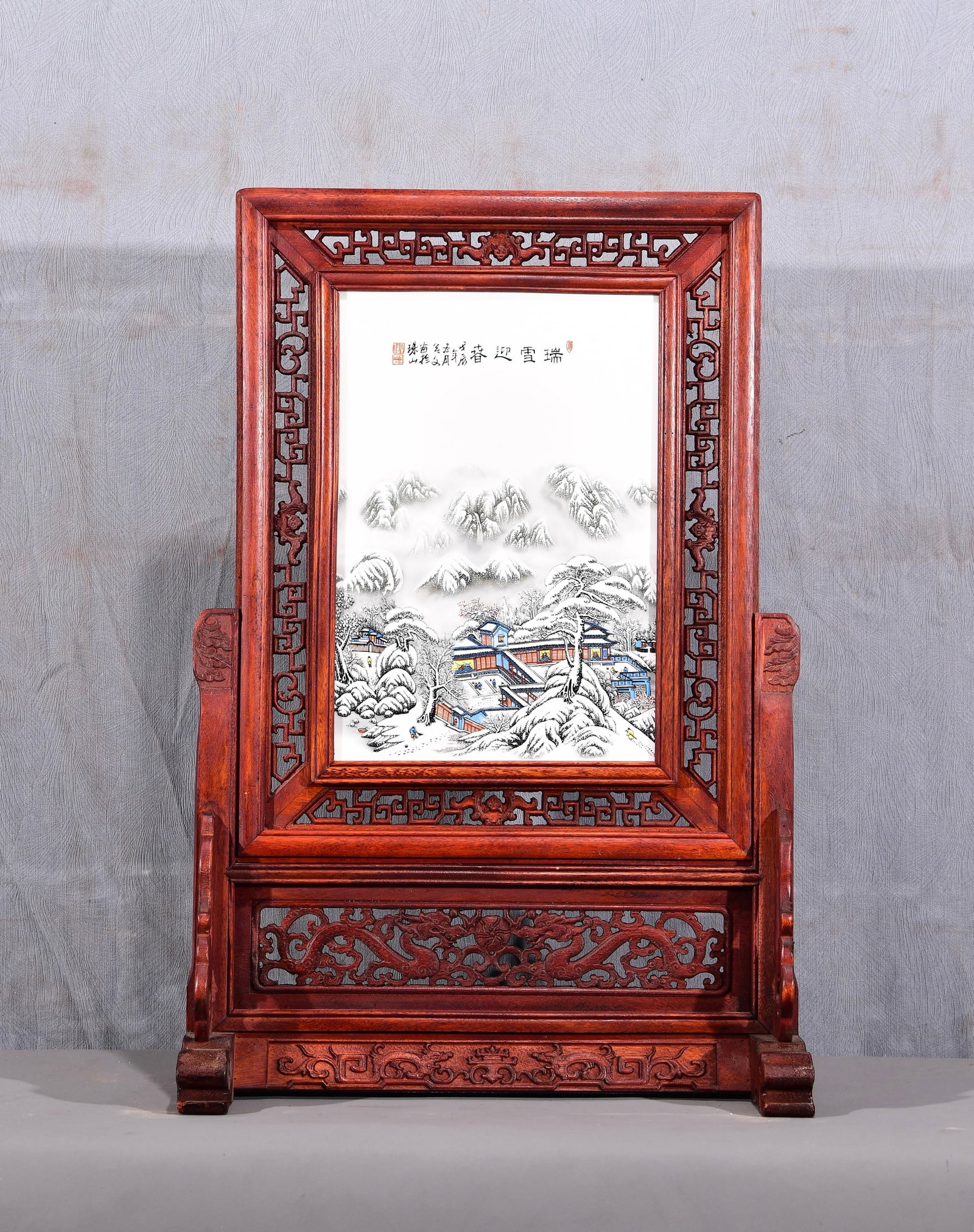 Exquisite! A vertical table screen with a famille rose snow scene porcelain panel inlaid in a: Exquisite! A vertical table screen with a famille rose snow scene porcelain panel inlaid in a mahogany openwork frame! "Welcoming Spring with Auspicious Snow" Dimensions: Height 67cm, Width 47cm Prove