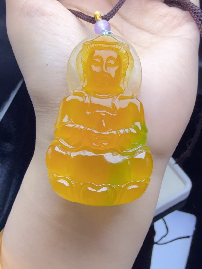 Jadeite of icy type with yellow and green flecks, depicting Guanyin.: The jadeite "Guanyin" piece, made of icy yellow jade with floating green hues, is translucent and lustrous, exquisitely three-dimensional, thick and full, and perfectly flawless. Provenance:Private co
