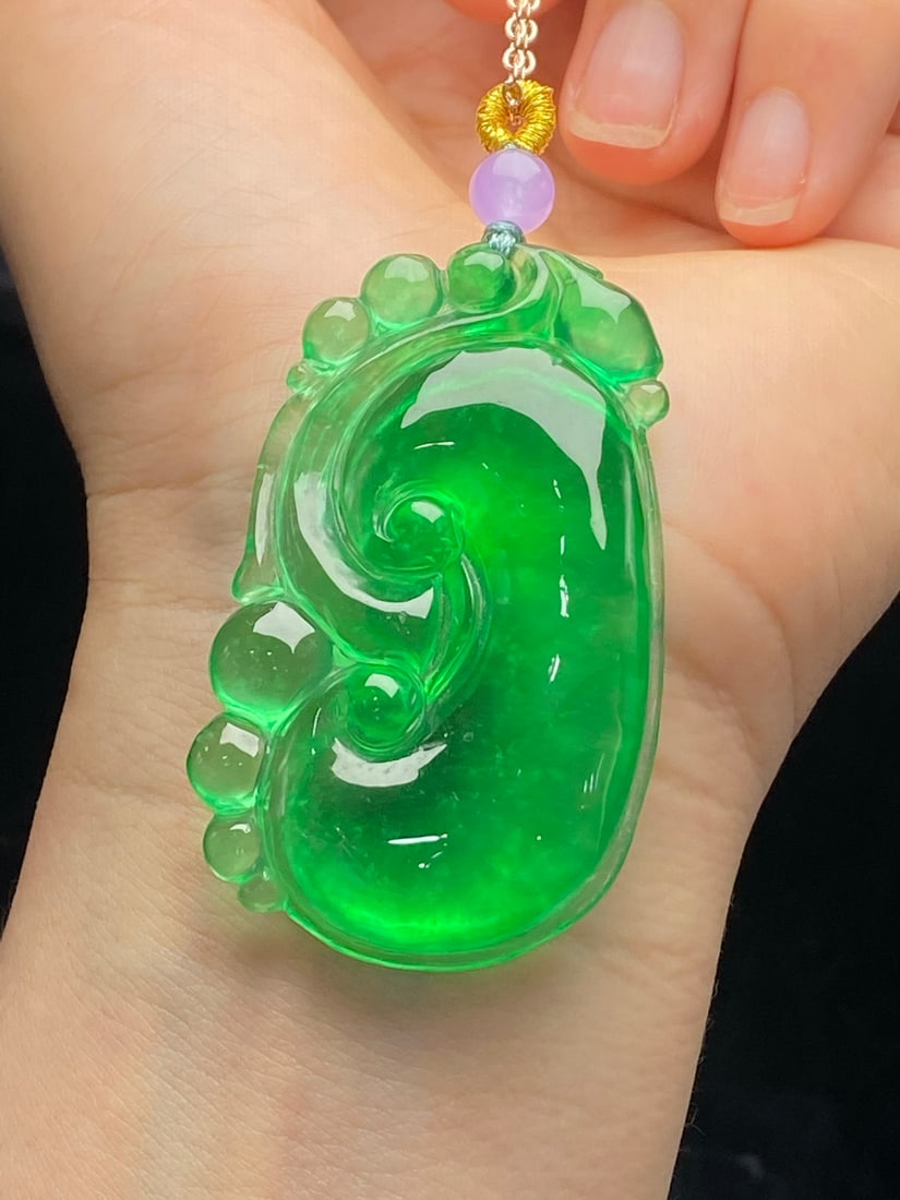 Jadeite icy green "Ruyi" pendant: This jadeite pendant, made of icy green jadeite with a full, lustrous sheen, features a fine texture, exquisite carving, and a substantial, full shape. It is flawless and free of cracks. Provenance:fr