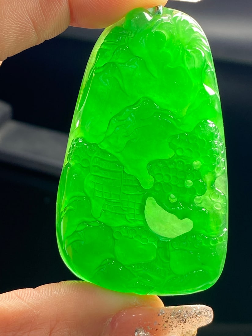 Jadeite pendant, icy green, full color, depicting landscape.: This jadeite pendant, made of icy green jadeite with a full green hue, is translucent and lustrous, with a fine texture and exquisite, three-dimensional carving. Provenance:from the collection of Geor