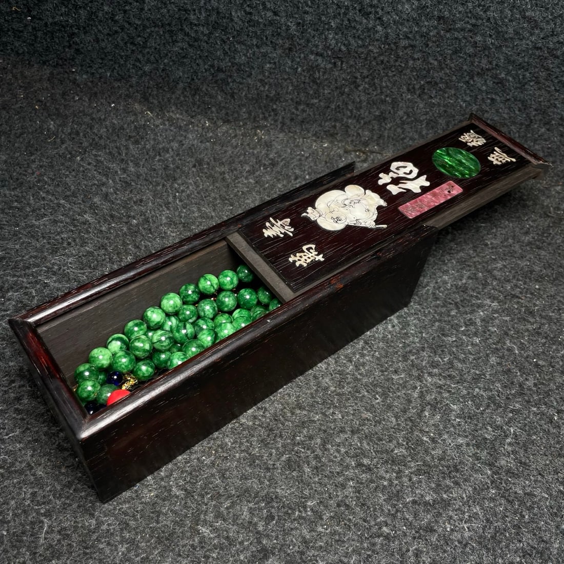 A precious jadeite court necklace is housed in a rosewood box inlaid with mother-of-pearl.: A precious jadeite court necklace is housed in a rosewood box inlaid with mother-of-pearl. Provenance:from the collection of George Stopher, Kent, purchased from P&M Waldo Antiques, London. We have an