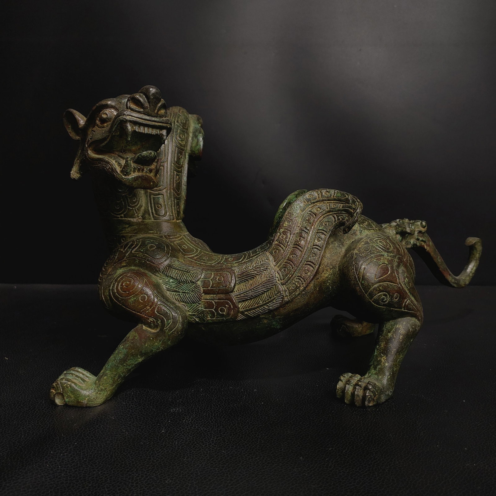 Bronze double-headed auspicious beast ornament from the old collection: This is a bronze mermaid-shaped artifact from the collection. The overall shape is that of a human head with a fish body, blending realism and mythological imagery, possessing both artistic value and 