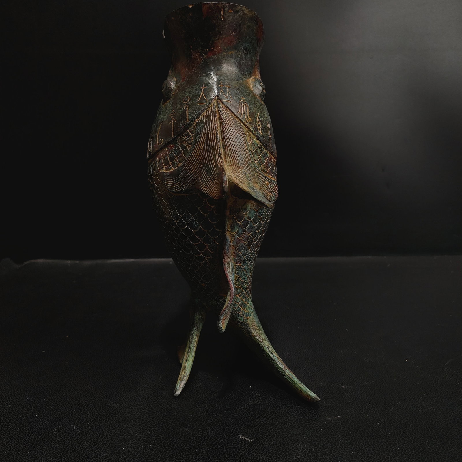 Former Collection of Bronze Fish-Shaped Zun: This Shang and Zhou dynasty bronze vessel with a human face is a uniquely shaped ritual vessel used by ancient nobles to hold wine or water. The lid is cast in the form of a complete human face, with 