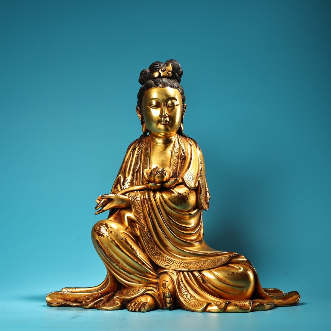 A rare, formerly owned bronze high-relief, gilt-bronze seated Guanyin Bodhisattva statue.: rare and exquisitely crafted seated Guanyin Bodhisattva statue in pure bronze with high relief carving and full gilding. Weighing 8000 grams, 35 cm high and 33 cm wide. Provenance:from the collection 