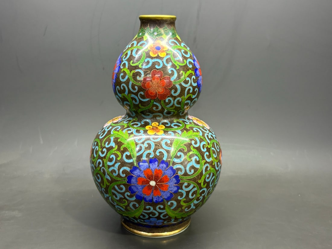 Ming Chenghua cloisonne enamel gourd-shaped bottle with lotus and floral design: A Ming Dynasty Chenghua period cloisonne enamel gourd-shaped vase with lotus and floral scroll design, measuring 20.5cm in height and 14cm in width. Provenance:Private collection from a professor in T