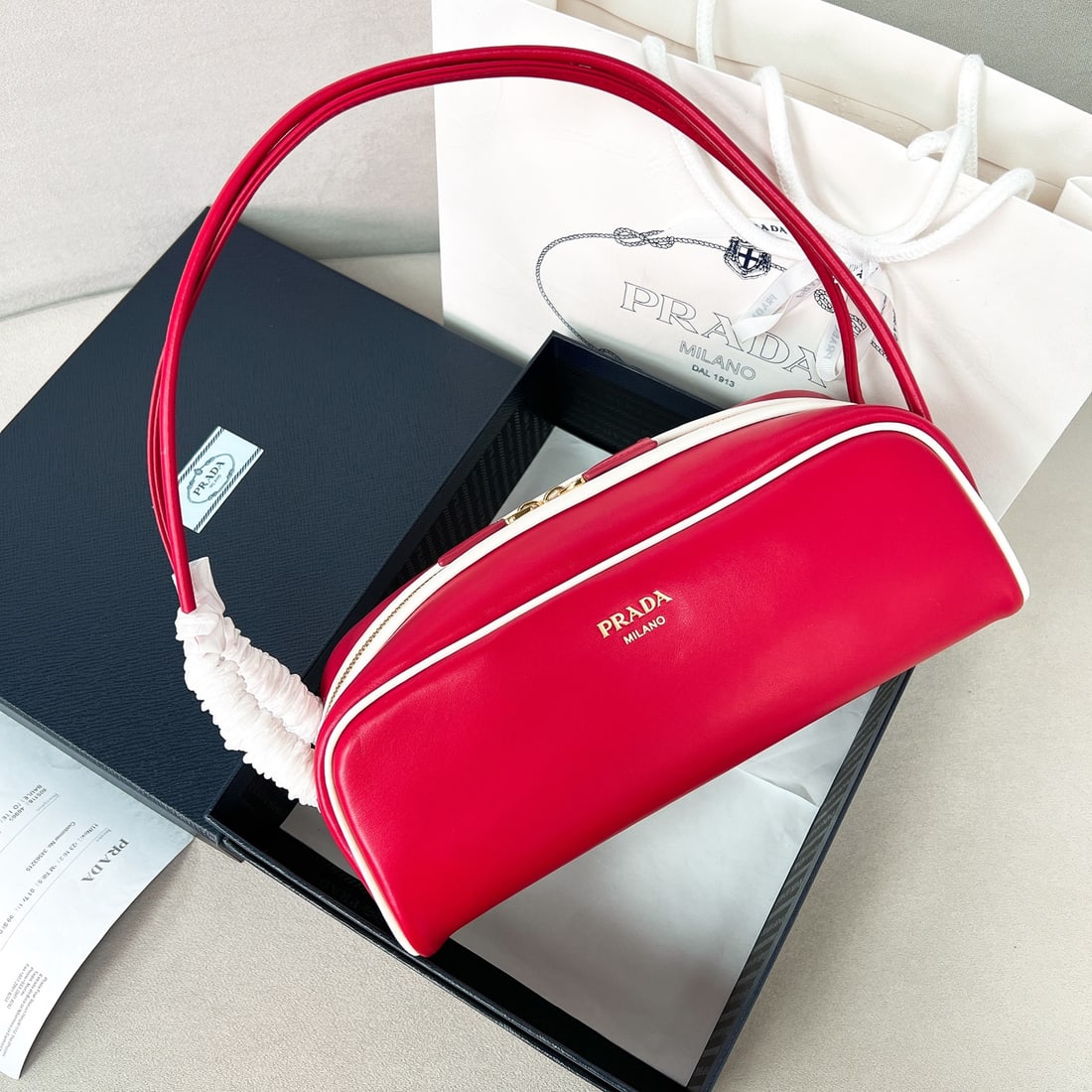 PRADA bowling bag: This bowling bag cleverly blends classic and modern elements. Made with imported cowhide and lined with imported sheepskin, it features contrasting trim at the opening for a stylish look, a practical 