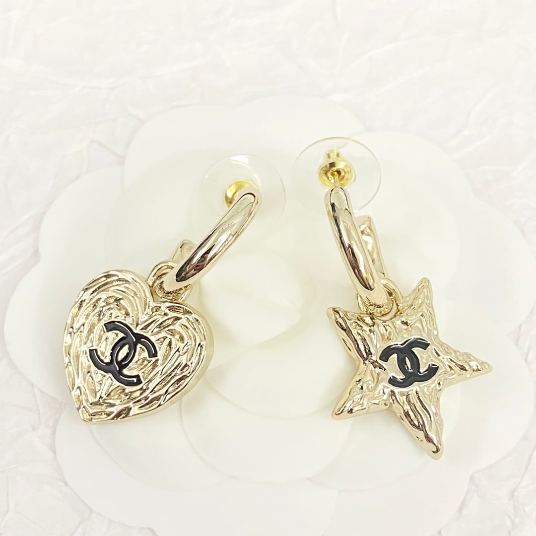 Chanel earrings with asymmetrical hooks and lava star design.: Chanel asymmetrical lava star earrings with curved hooks and asymmetrical hearts and stars, featuring a lava texture that exudes a vintage feel while remaining stylish and sophisticated. The gold meta