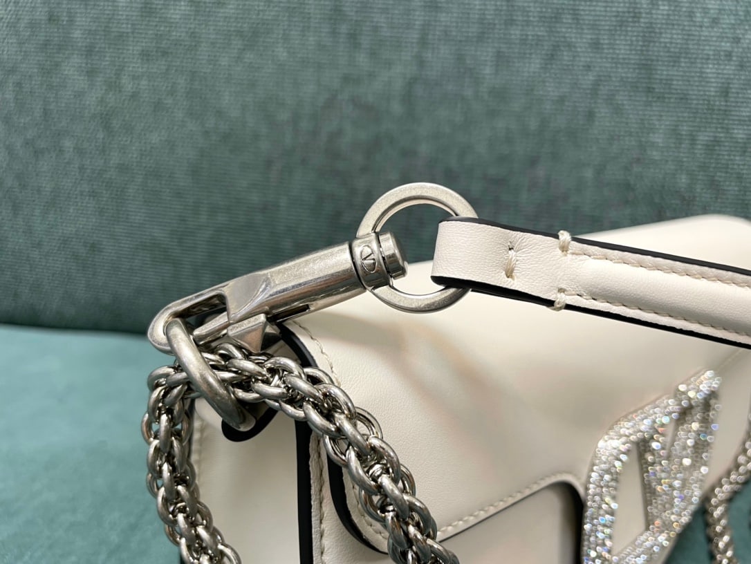 Valentino: Valentino calfskin handbag with star-studded buckle, featuring a vintage brass distressed finish, magnetic closure, and soft lambskin lining. We offer FREE SHIPPING for both domestic and