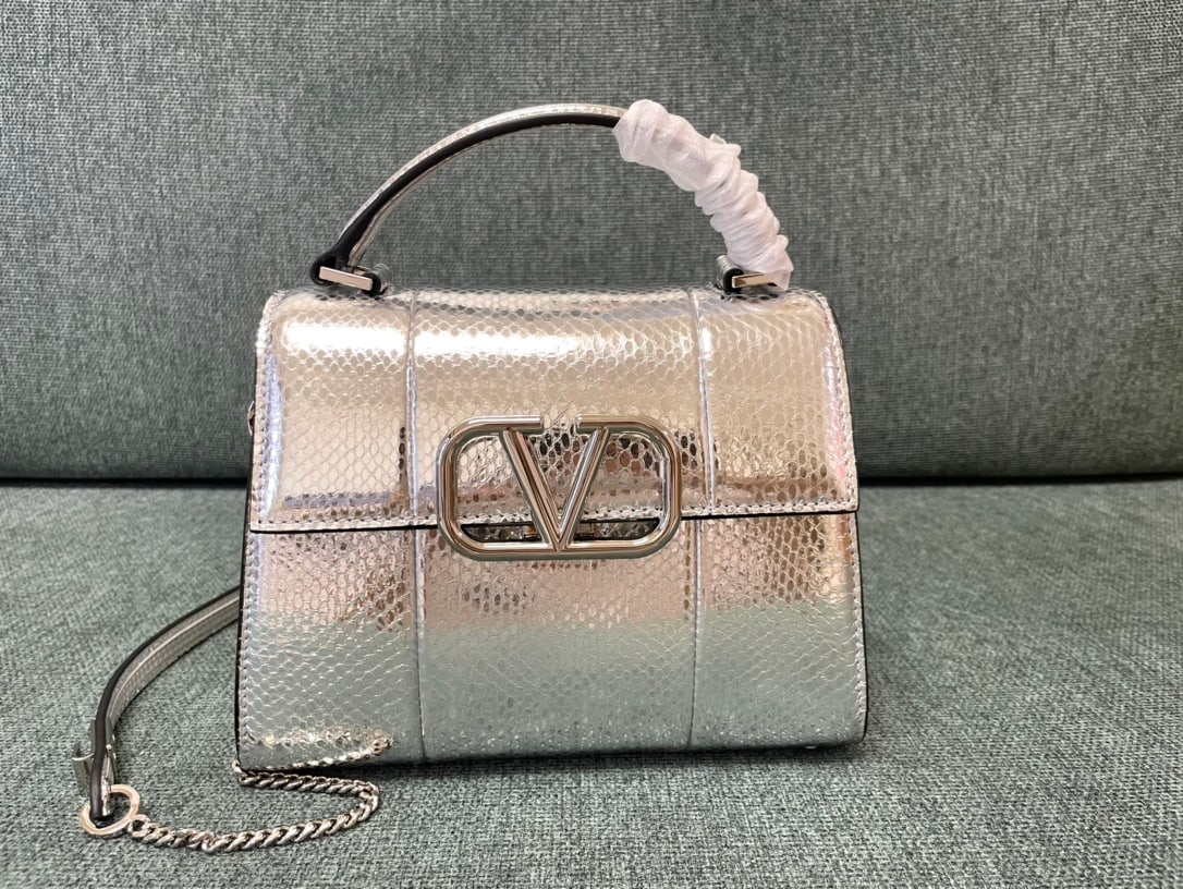 Valentino Garavani VSLING: The silver snake mini Valentino Garavani VSLING Valentino briefcase features an extendable two-tone shoulder strap and handle, allowing for easy switching between shoulder, crossbody, and hand carry. 