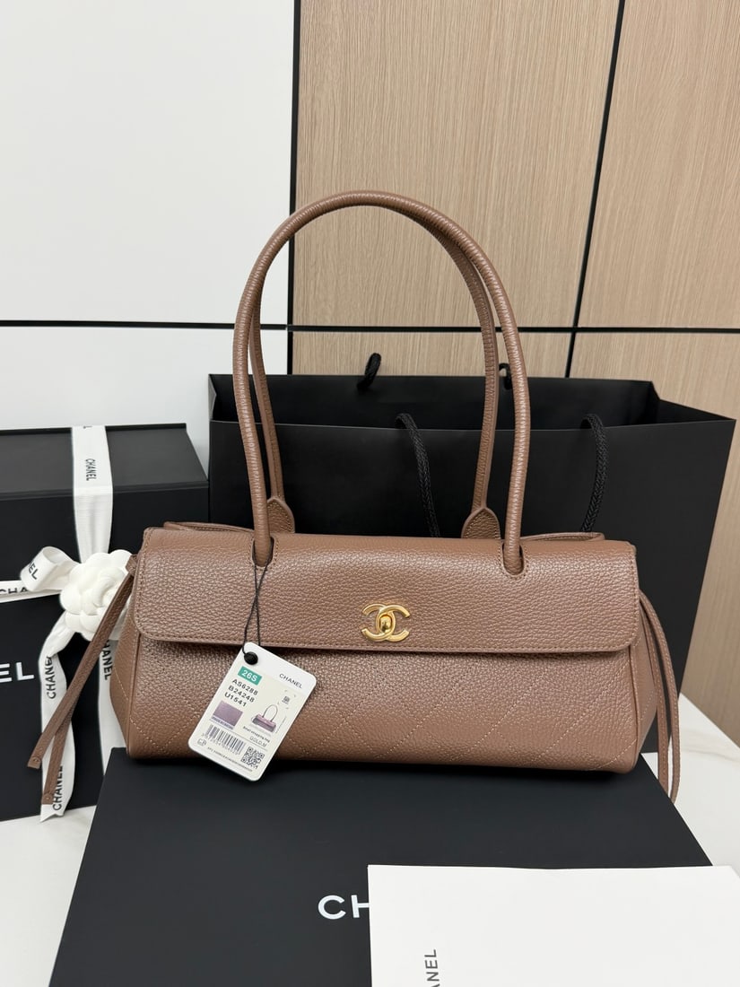 CHANEL baguette bag with lychee pattern and black bowling ball design: Spring/Summer Baguette Bag in Black with a Lychee Grain Texture, resembling a bowling ball! The classic quilted pattern paired with small gold hardware allows it to hold all your everyday essentials. 
