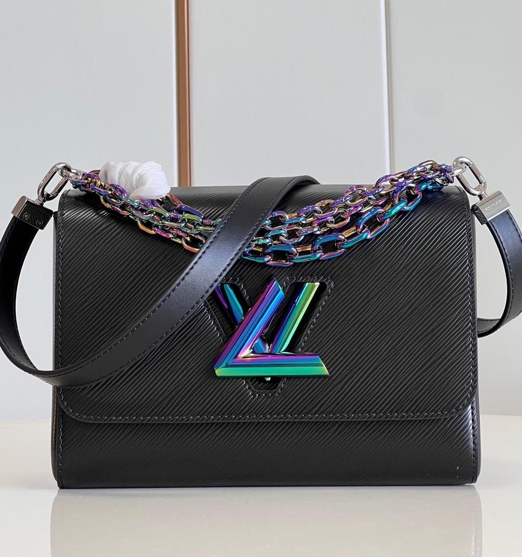 LV Twist: The medium-sized Twist handbag is crafted from Epi grain leather, featuring a beetle-like iridescent sheen on the LV Twist lock and chain handles. Part of the chain is integrated into the leather shou