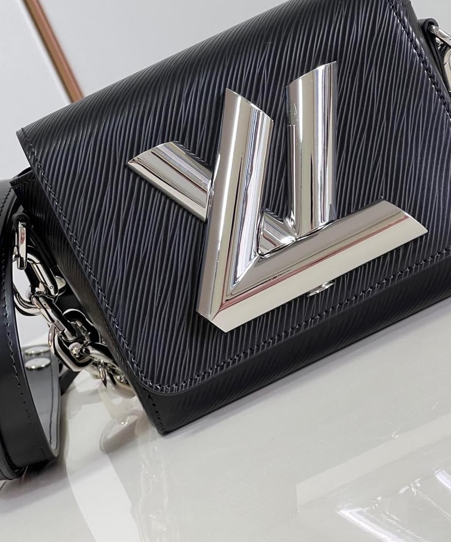 LV Twist: Reinterpreting the classic LV handbag with a change in proportion, LV Women's Artistic Director Nicolas Ghesqui??re crafted the Twist Lock XL from Epi calfskin, adorned with a giant LV Twist lock, sho