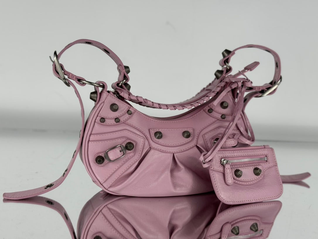 Balenciaga: Balenciag Le Cagole, a half-moon shaped shoulder bag in the Balenciag Le Cagole collection, pays homage to the classic motorcycle bag series. It's a significant upgrade from the traditional motorcycle