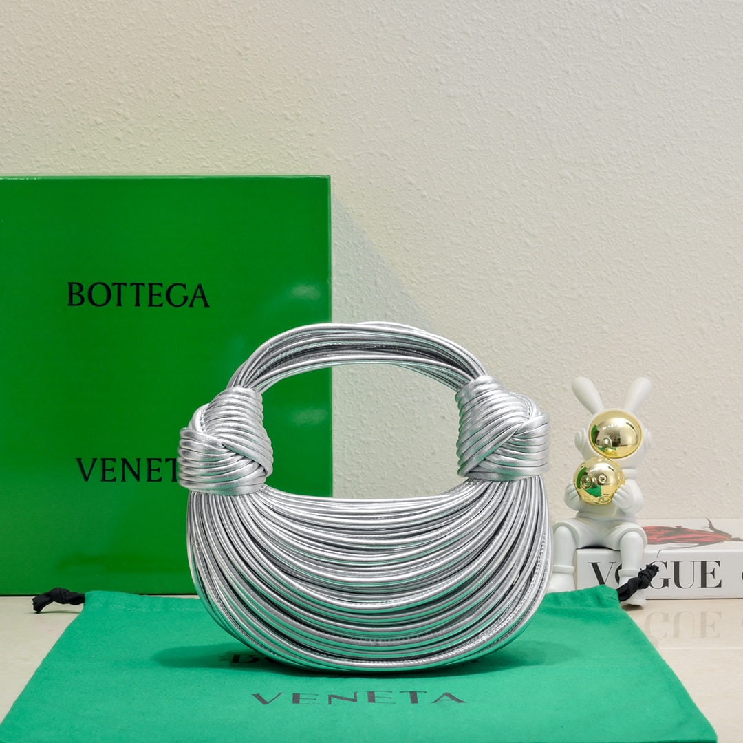 Bottega Veneta: The Bottega Veneta Jodie Ramen clutch bag features a unique and playful design inspired by the designer. Made inside and out from imported lambskin, its supple shape, adorned with a novel knot
