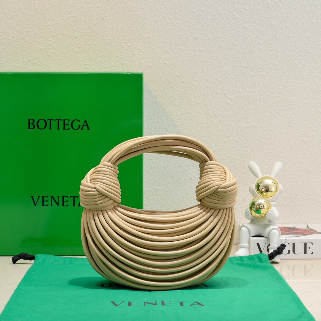 Bottega Veneta: The Bottega Veneta Jodie Ramen clutch bag features a unique and playful design inspired by the designer. Made inside and out from imported lambskin, its supple shape, adorned with a novel knot