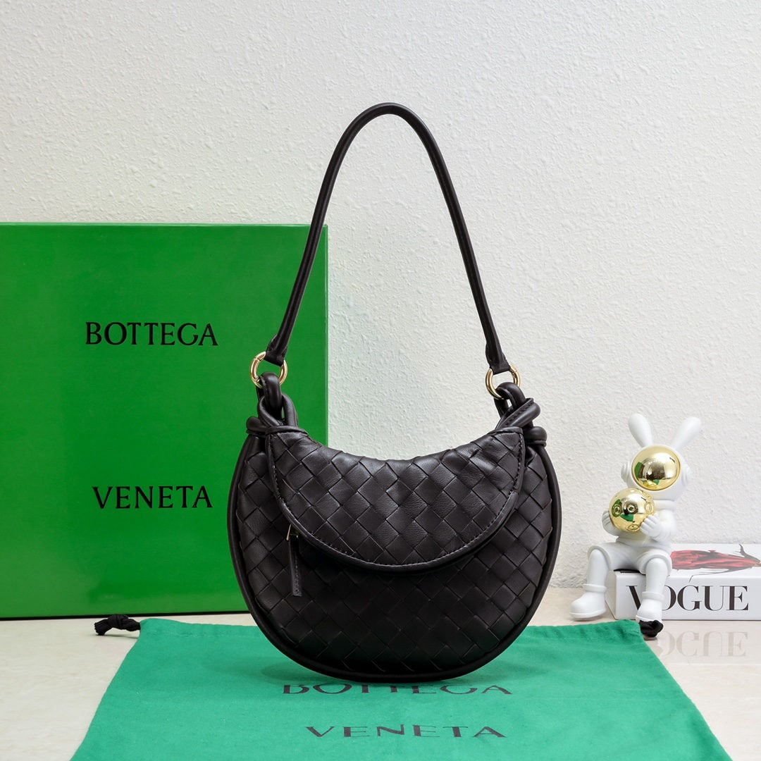 Bottega Veneta: The Bottega Veneta Gemelli twin bag is a pair of two half moon shaped Gemelli bags paired together, crafted from the brand's signature intrecciato woven lambskin. It features detachable tubular handle