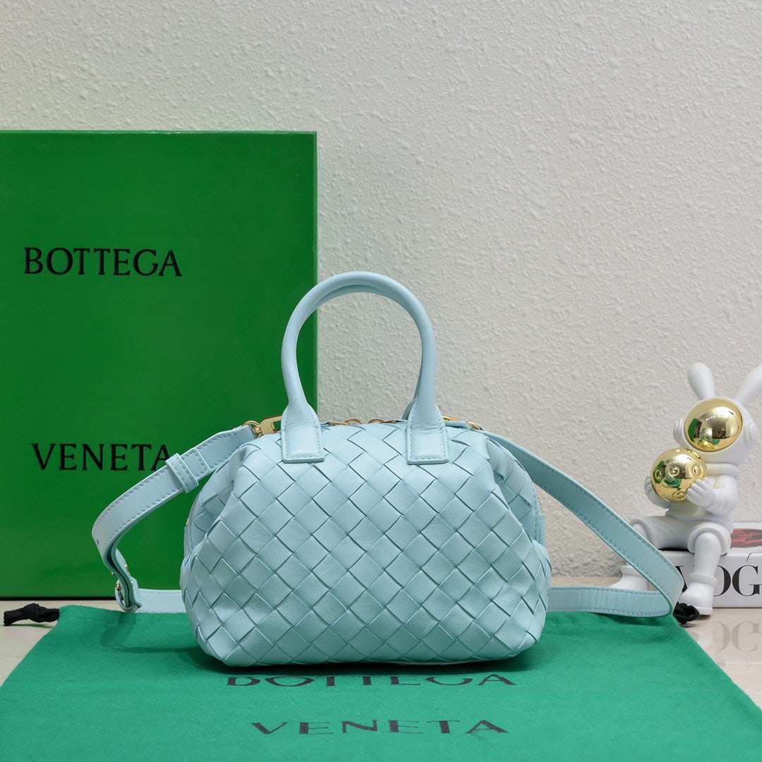 Bottega Veneta: The Bottega Veneta Small Intrecciato woven leather bowling bag features a detachable crossbody strap, a single interior flat pocket, and a zip closure. The classic woven craftsmanship is an indispensa
