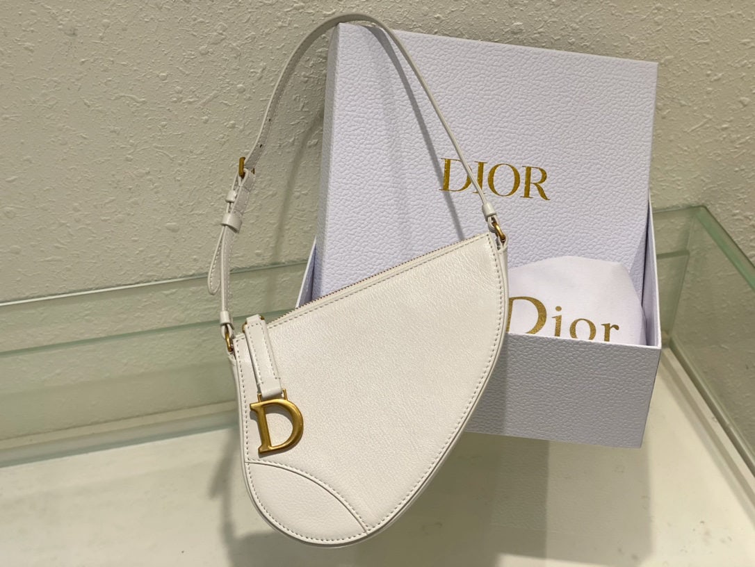 Christian Dior Saddle Bag: The Dior Saddle Bag clutch is part of the 2024 Early Spring collection, reinterpreting classic elements of the namesake collection, such as the vintage gold plated metal stirrup D shaped charm.