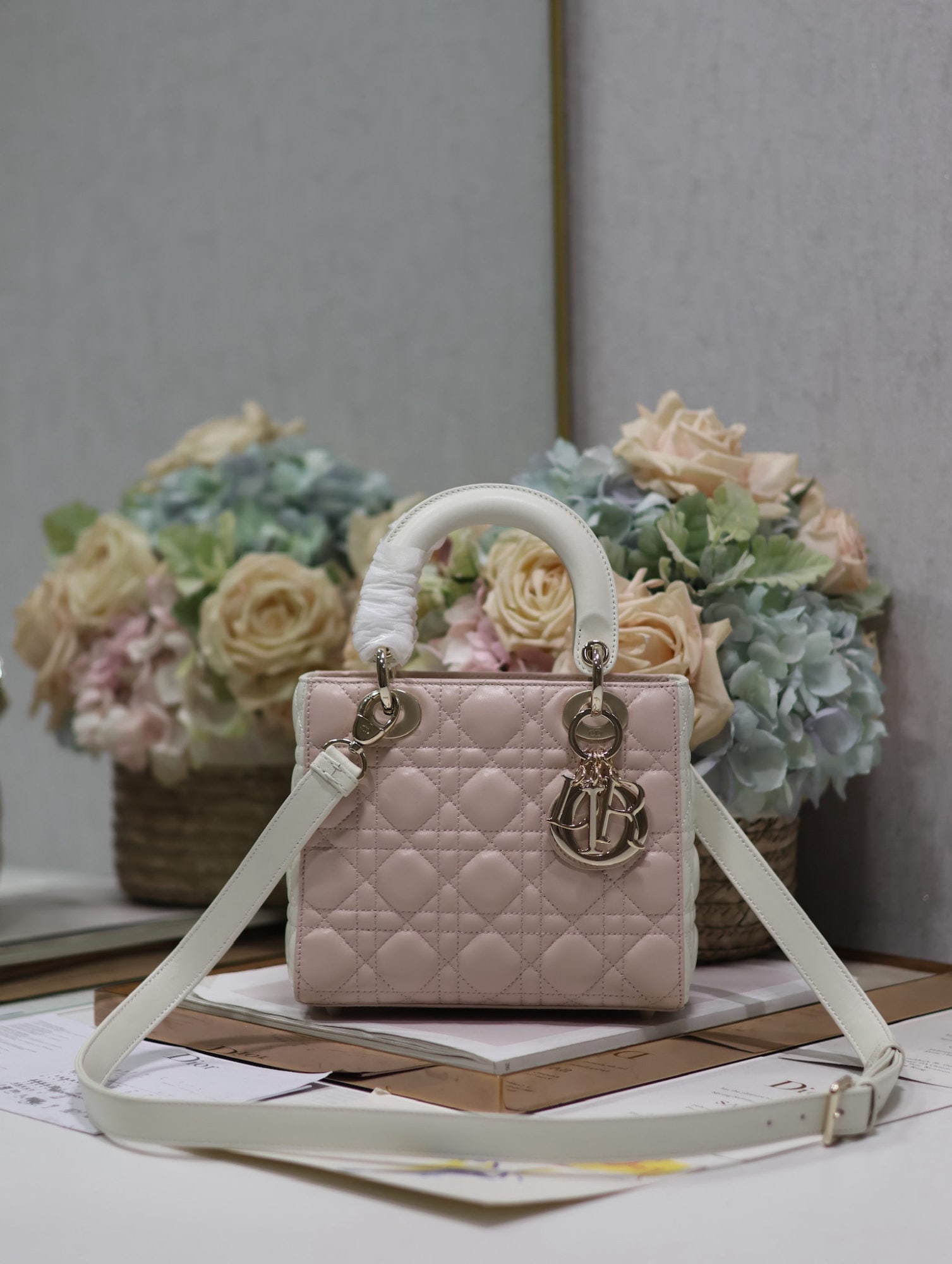 Christian Dior: The Lady Dior color blocked pink and white four compartment lambskin handbag embodies Dior's profound insight into elegance and beauty. Crafted from lambskin, it features quilted details with the icon