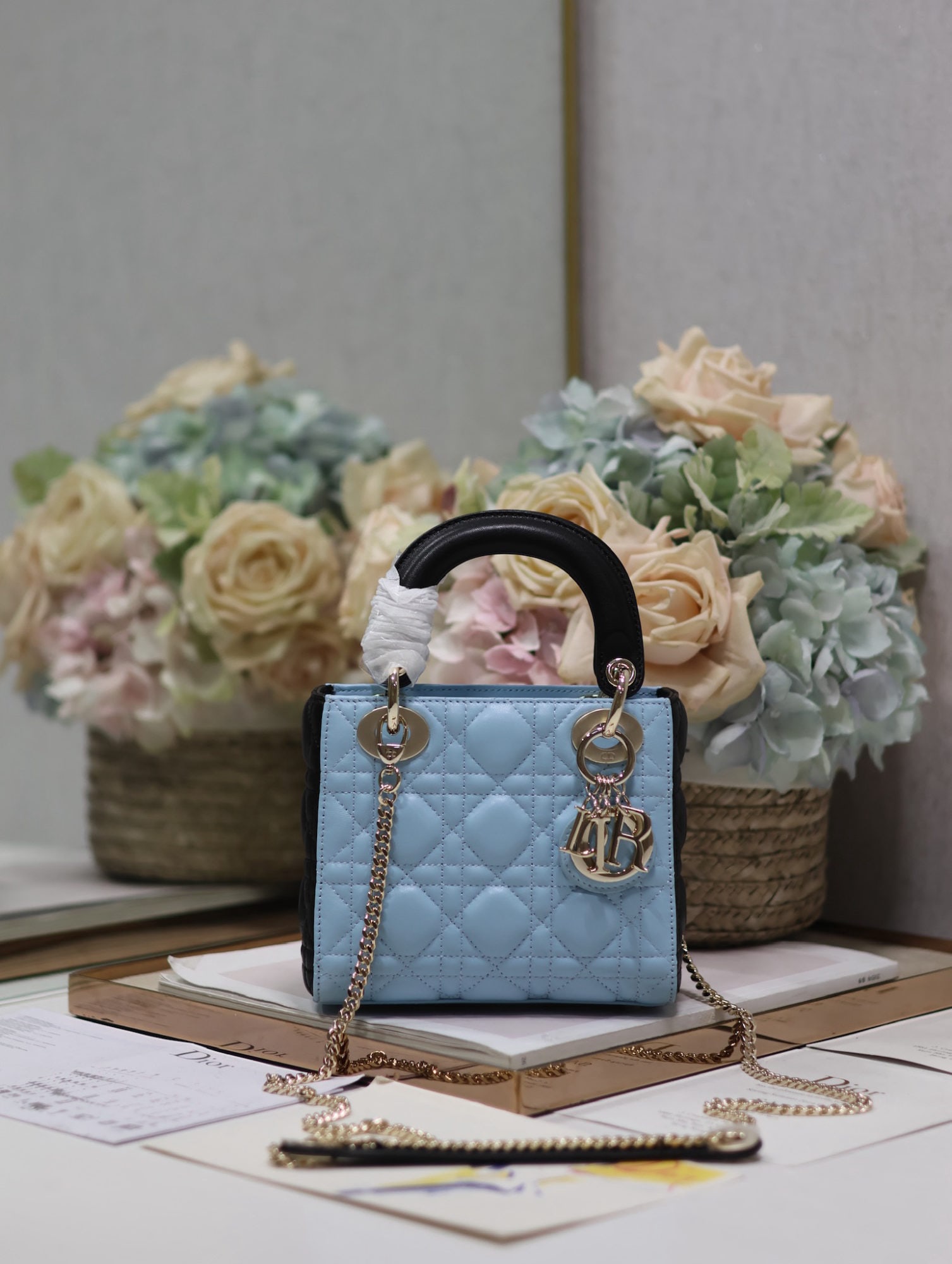 Christian Dior: The Lady Dior two tone blue and black three compartment lambskin handbag with a single chain shoulder strap embodies Dior's profound insight into elegance and beauty. Crafted from lambskin, it