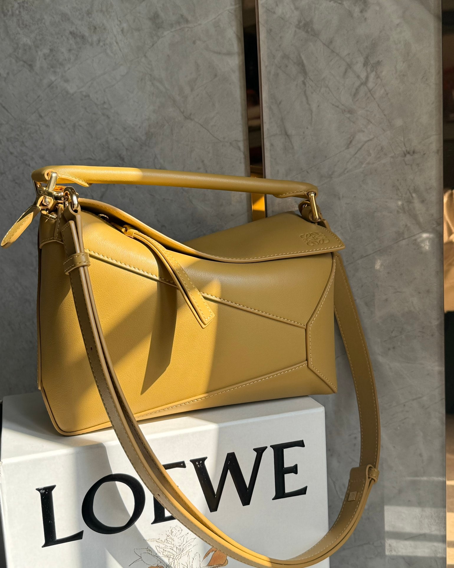 LOEWE: The LOEWE Desert Yellow Puzzle bag is made of calfskin. It's lightweight yet has a surprisingly large capacity, making it practical, versatile, and convenient for travel. Small size: 24 x 16 x 10 cm. 